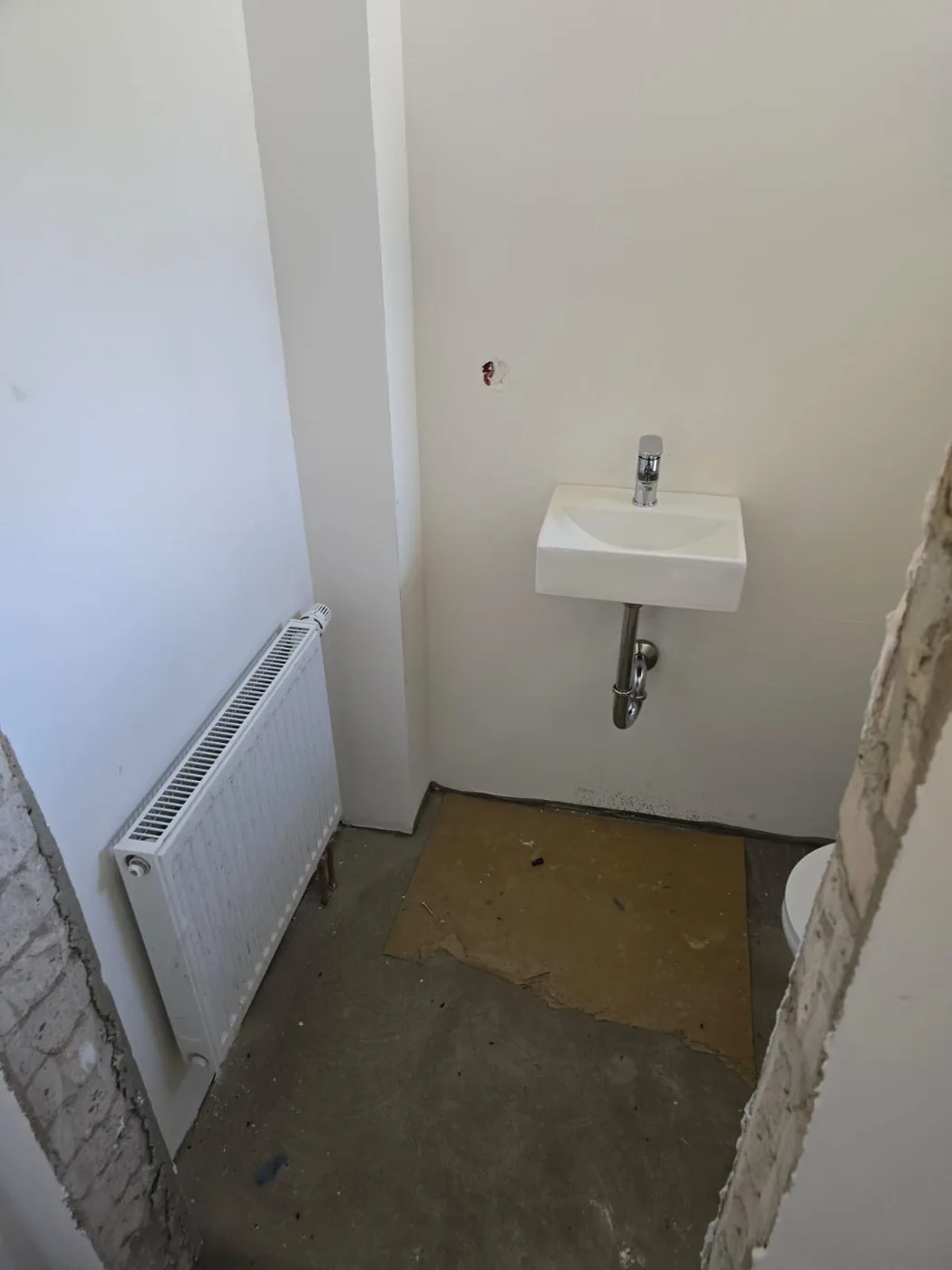 Waschbecken und Heizkörper im Gäste-WC während der Sanierung