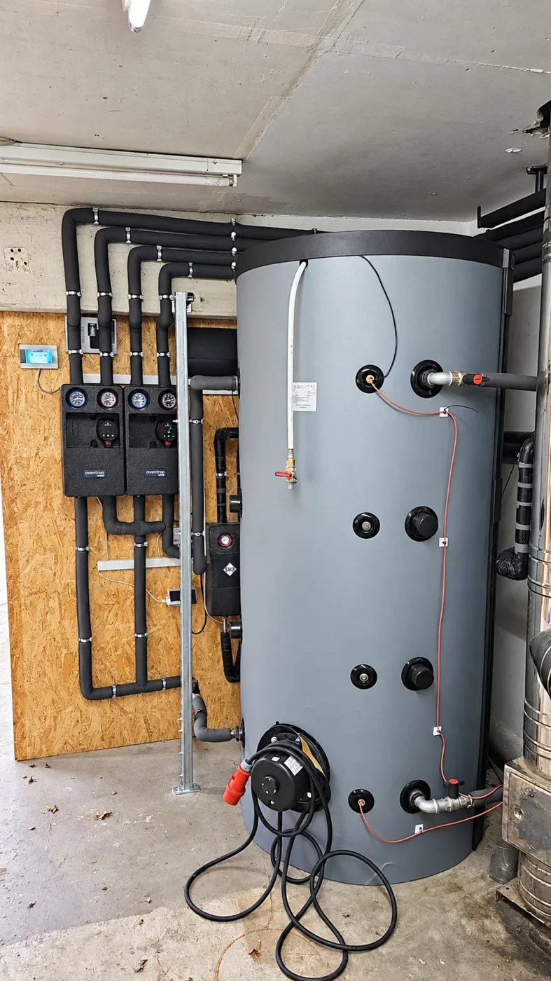 Pufferspeicher der Pelletanlage mit Rohrleitungen und Pumpengruppen